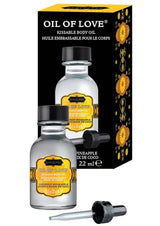 Kama Sutra Oil of Love Coconut Pineapple — two clear glass bottles with dropper and black gift box packaging, golden amber label, 22ml